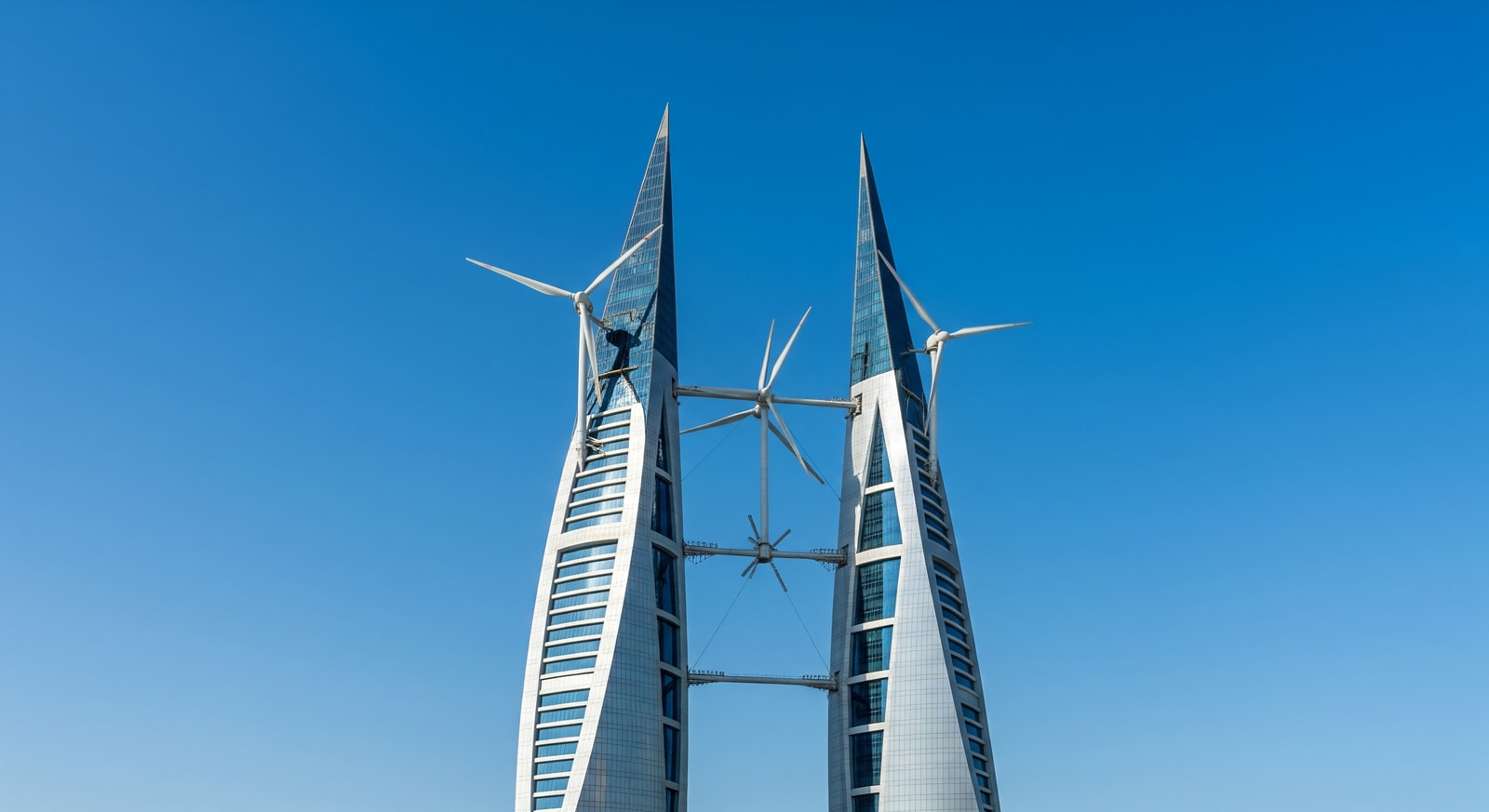 Bahrain World Trade Center twin towers with wind turbines connecting the buildings against blue sky in Manama