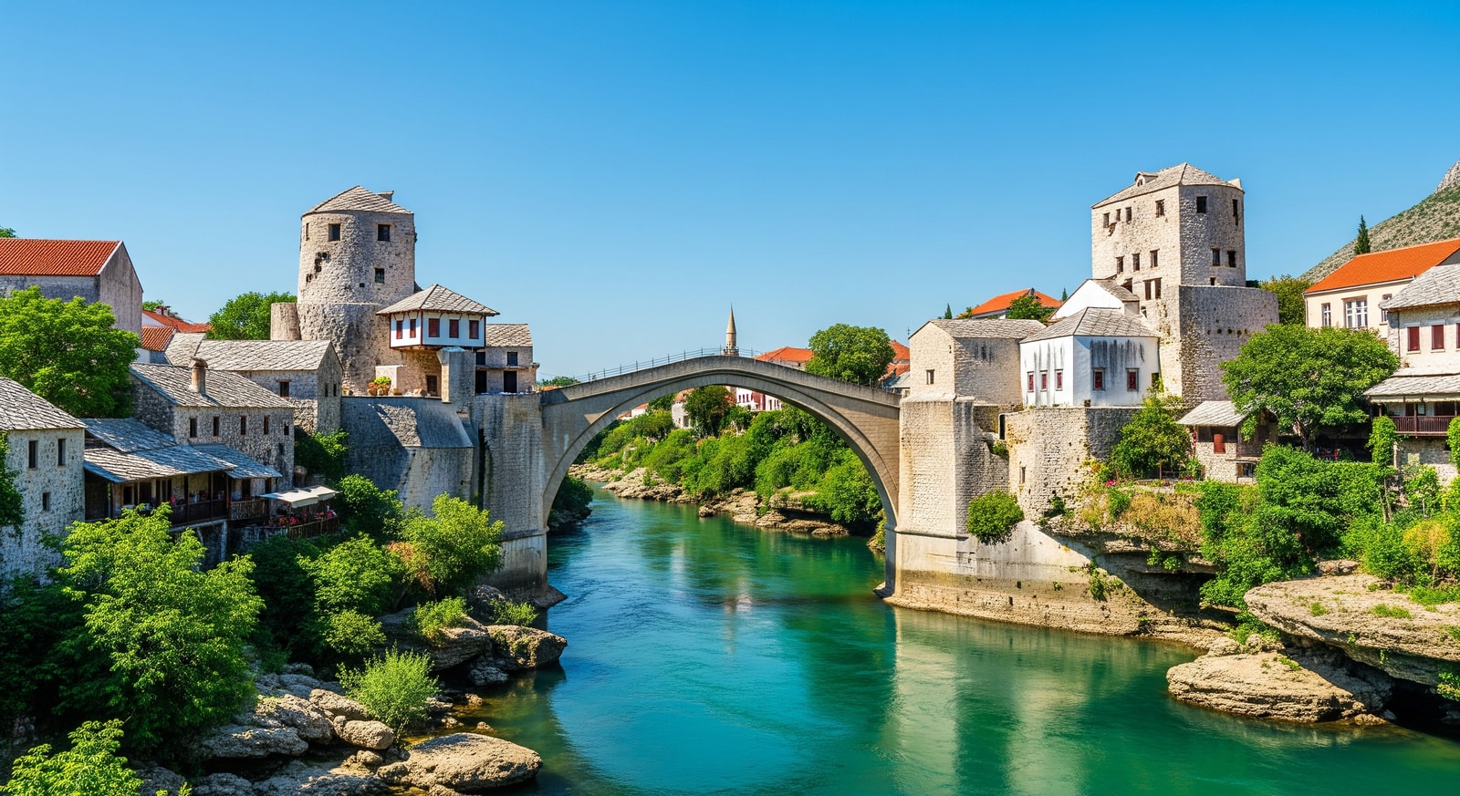 Iconic Stari Most Ottoman bridge in Mostar spanning the emerald green Neretva River with traditional stone houses