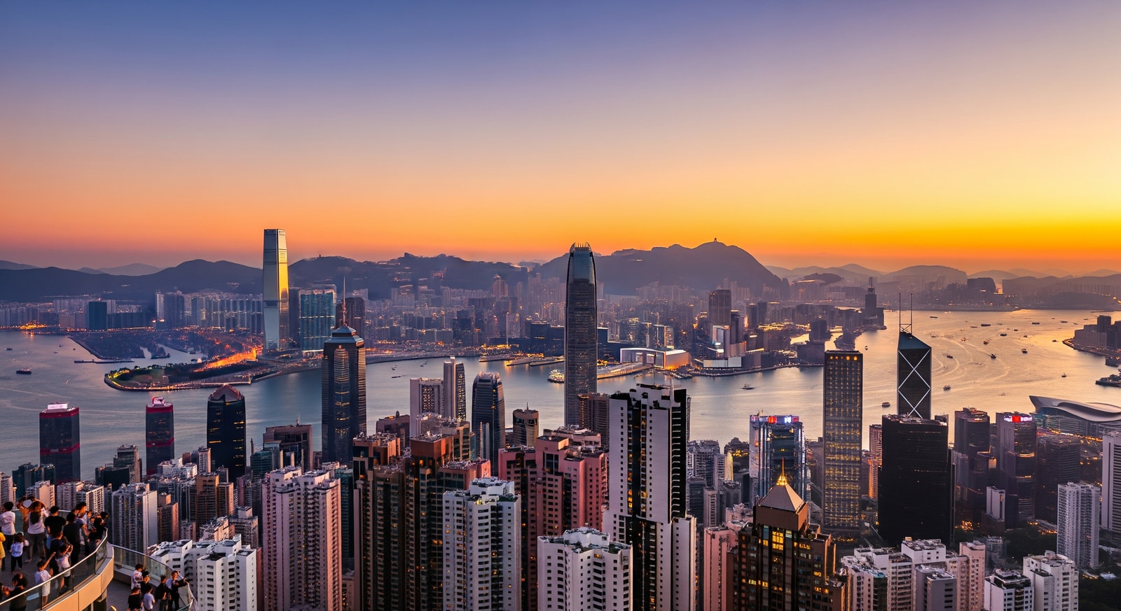 Panoramic view of Hong Kong Island skyline from Victoria Peak during golden hour with harbor below