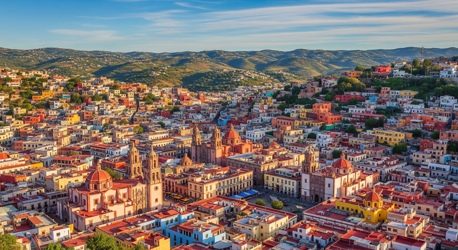 Colorful colonial buildings of Guanajuato city cascading down hillsides with historic churches and plazas