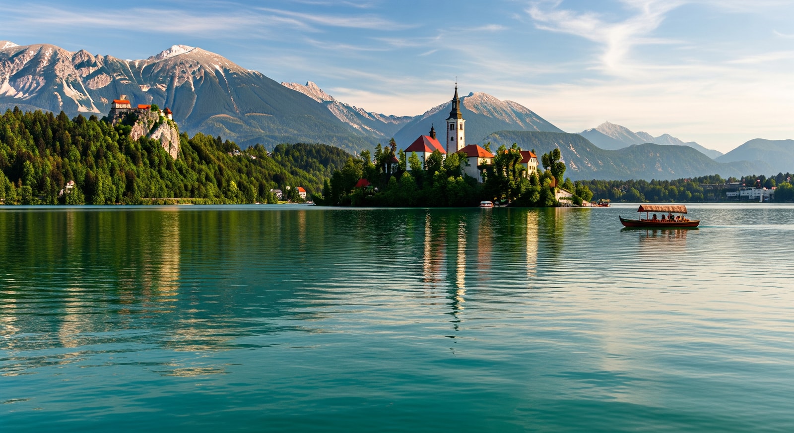 Iconic Lake Bled with its island church and Bled Castle overlooking the emerald waters surrounded by Julian Alps