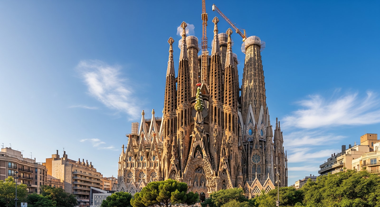 The iconic Sagrada Familia basilica in Barcelona with its towering spires against a blue sky
