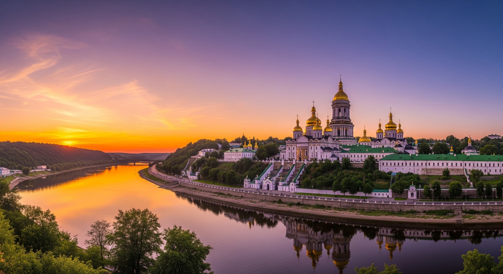 Kyiv Pechersk Lavra monastery complex with its iconic golden domes overlooking the Dnipro River at sunset